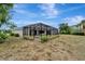 Backyard view featuring a screened lanai with swimming pool and lush surroundings at 168 Wading Bird Dr, Venice, FL 34292