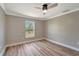 Bright bedroom with wood-look floors and window with a view of lush greenery at 168 Wading Bird Dr, Venice, FL 34292