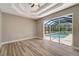 Bedroom featuring wood floors, neutral walls, ceiling fan and a view of the pool at 168 Wading Bird Dr, Venice, FL 34292