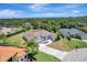 Aerial view of a home with a well-manicured lawn, palm trees, and a circular driveway at 168 Wading Bird Dr, Venice, FL 34292