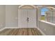 Inviting entryway features double doors, transom window, and wood-look floors at 168 Wading Bird Dr, Venice, FL 34292
