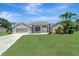 Charming single-story home boasts a manicured lawn and mature palm trees at 168 Wading Bird Dr, Venice, FL 34292