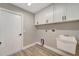 Well-equipped laundry room with white cabinets and utility sink, offering functionality and storage at 168 Wading Bird Dr, Venice, FL 34292