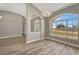 Elegant living room with arched entryway, columns, wood-look floors, modern lighting and a large window at 168 Wading Bird Dr, Venice, FL 34292