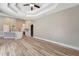 Open concept living room with adjacent kitchen with wood floors, neutral walls, and a decorative ceiling fan at 168 Wading Bird Dr, Venice, FL 34292