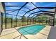 A screened-in pool with lush landscaping and a view of the backyard at 168 Wading Bird Dr, Venice, FL 34292