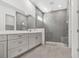 Modern bathroom featuring a large gray tiled shower with glass enclosure and a double sink vanity at 17719 Palmiste Dr, Bradenton, FL 34202
