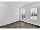 Well-lit bedroom with dark wood floors, white walls, and two windows framing neighborhood views at 17719 Palmiste Dr, Bradenton, FL 34202