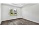 Bright bedroom featuring hardwood floors, white walls, and a window offering views of the greenery at 17719 Palmiste Dr, Bradenton, FL 34202