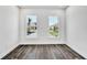 Bright bedroom with dark wood floors, two windows with neighborhood views, and white walls at 17719 Palmiste Dr, Bradenton, FL 34202