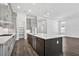 Bright kitchen featuring a large island with sink, sleek cabinetry, and a spacious pantry at 17719 Palmiste Dr, Bradenton, FL 34202