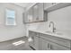 Bright laundry room featuring gray cabinets, white countertops, a sink, and tile floors at 17719 Palmiste Dr, Bradenton, FL 34202