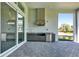 Outdoor kitchen featuring stainless steel appliances, dark cabinetry, and brick flooring at 17719 Palmiste Dr, Bradenton, FL 34202