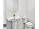 Clean powder room with a white pedestal sink, bronze faucet, toilet, and a round mirror at 17719 Palmiste Dr, Bradenton, FL 34202