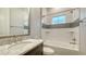 Clean bathroom featuring a tub and shower combo with a speckled quartz sink and a framed mirror at 17811 Roost Pl, Bradenton, FL 34211