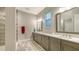 Elegant bathroom with double vanity, a stand-alone shower and a large window at 17811 Roost Pl, Bradenton, FL 34211