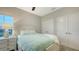 Cozy bedroom with a plush aqua bedspread, bedside table, and a view from the window at 17811 Roost Pl, Bradenton, FL 34211