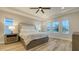 Serene bedroom with tray ceiling, natural light from large windows, and views of the water at 17811 Roost Pl, Bradenton, FL 34211