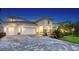 Elegant home showcasing a paved driveway, three-car garage, stone accents and a beautifully landscaped front yard at 17811 Roost Pl, Bradenton, FL 34211