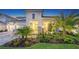 Beautifully landscaped home exterior featuring a covered entryway, stone accents, and lush tropical foliage at 17811 Roost Pl, Bradenton, FL 34211