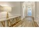 Bright foyer with decorative table, hardwood floors, and a view of the front door at 17811 Roost Pl, Bradenton, FL 34211