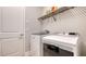 Bright laundry room with modern, stainless-steel washer and dryer, plus built-in shelving for convenient storage at 17811 Roost Pl, Bradenton, FL 34211