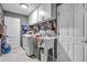 Well-equipped laundry room with modern washer, sink, storage cabinets, and white doors at 1809 Buccaneer Ter, Sarasota, FL 34231