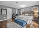 Cozy main bedroom with wood floors, a comfortable bed, a blue storage bench, and plenty of natural light at 1809 Buccaneer Ter, Sarasota, FL 34231
