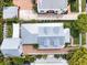 Well-manicured property with brick driveway, mature trees, manicured shrubs, and a metal roof on a two-story home at 1841 Datura St, Sarasota, FL 34239