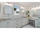 Bright bathroom with double sinks, granite counters, custom cabinets, and black & white tiled floors at 1841 Datura St, Sarasota, FL 34239
