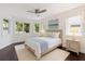 Bright bedroom with many windows, dark wood floors, ceiling fan, and beach-themed decor at 1841 Datura St, Sarasota, FL 34239