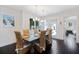 Bright dining room with dark wood floors, stylish wicker chairs, and modern chandelier lighting at 1841 Datura St, Sarasota, FL 34239