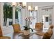 Elegant dining room with large windows, wood table, wicker chairs, and stylish chandelier at 1841 Datura St, Sarasota, FL 34239