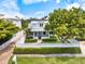 Charming two-story home with a white picket fence and lush landscaping creating a welcoming curb appeal at 1841 Datura St, Sarasota, FL 34239