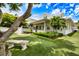 Beautifully landscaped backyard with mature trees, outdoor seating, and a charming two-story home at 1841 Datura St, Sarasota, FL 34239