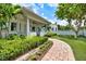 Charming home with lush landscaping, brick pathway, covered porch, and outdoor seating to enjoy the outdoors at 1841 Datura St, Sarasota, FL 34239