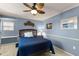 Comfortable bedroom with a blue bed, side table with lamp, and decorative wall hangings at 1904 Nw 79Th St, Bradenton, FL 34209