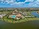 A scenic aerial view of the community showcasing the pool, clubhouse, tennis courts, and lake access at 20542 Trattoria Loop, Venice, FL 34293