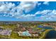 A stunning aerial view of the community showing lakes, tennis courts, and a sparkling pool on a sunny day at 20542 Trattoria Loop, Venice, FL 34293