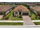 Aerial view of a home featuring a red tile roof, green lawn, and a community pond at 20542 Trattoria Loop, Venice, FL 34293