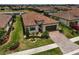 High aerial view of a home with well-maintained landscaping, a brick paver driveway and tile roof at 20542 Trattoria Loop, Venice, FL 34293