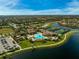 An aerial view of a resort-style community with a pool, tennis courts, and beautiful landscaping at 20542 Trattoria Loop, Venice, FL 34293