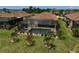 Aerial view of a backyard featuring a screened-in pool, spa, and lounge chairs, surrounded by palm trees and landscaping at 20542 Trattoria Loop, Venice, FL 34293