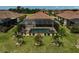 Aerial view of a backyard with a screened-in pool, spa, lounge chairs, and tropical landscaping with palm trees at 20542 Trattoria Loop, Venice, FL 34293
