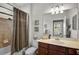 Well-lit bathroom featuring a shower-tub combo and vanity with warm color tones at 20542 Trattoria Loop, Venice, FL 34293