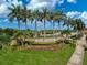 Gran Paradiso community entrance with palm trees and landscaping against a sunny blue sky at 20542 Trattoria Loop, Venice, FL 34293