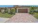 Home exterior featuring manicured landscaping, a brick paver driveway, and a two-car garage at 20542 Trattoria Loop, Venice, FL 34293