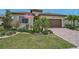 Charming home exterior showcasing a brick paver driveway and lush, tropical landscaping at 20542 Trattoria Loop, Venice, FL 34293