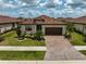 Aerial view of home featuring a tile roof, well-maintained landscaping, and brick paver driveway at 20542 Trattoria Loop, Venice, FL 34293