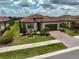 Charming home with a red tile roof, manicured lawn, and a brick paver driveway at 20542 Trattoria Loop, Venice, FL 34293